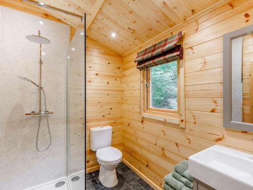 a wooden bathroom with a toilet and a shower at 1 Bed in Ironbridge 88768 in Leighton