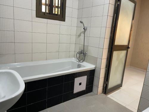a bathroom with a bath tub and a sink at LGH (Luxury Guest House) Résidence in Lomé