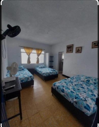 una camera con due letti, un tavolo e una finestra di Hotel Guaipa melgar a Melgar