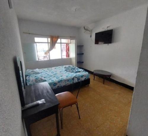 una camera con letto, scrivania e TV di Hotel Guaipa melgar a Melgar