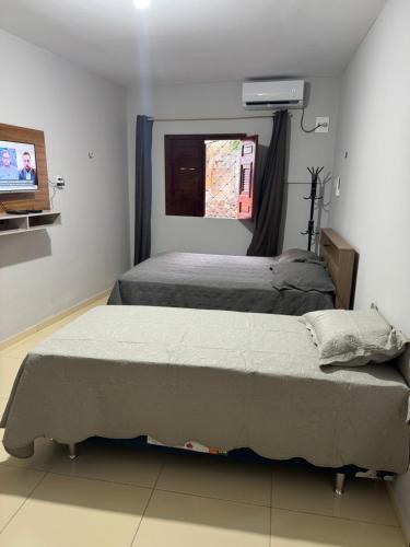 um quarto com duas camas e uma televisão em Lindo apartamento coração de Picos em Picos