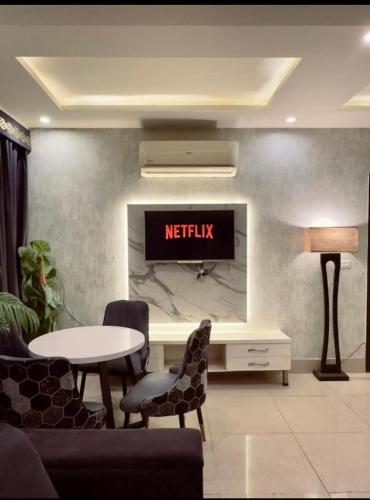 un soggiorno con TV a parete di 1 bed apartment available in Al nadd a Sharjah