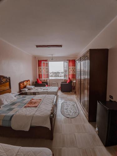 1 dormitorio con 3 camas y sala de estar en TOP HOTEL en Asuán