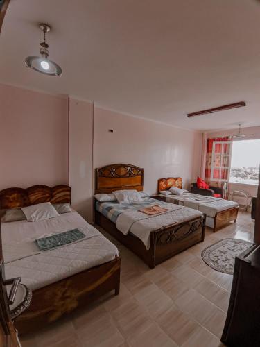 1 dormitorio con 2 camas y sofá en TOP HOTEL, en Asuán