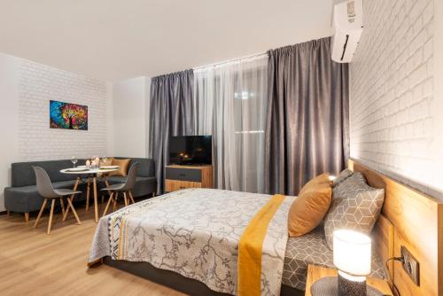 a hotel room with a bed and a dining room at Best Guest 2 Apartments in Plovdiv