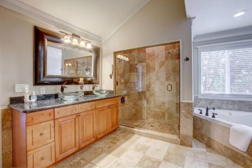 y baño con 2 lavabos, ducha y bañera. en Popular East Atlanta Village Sleeps16, Spacious, Comfortable Home Close To Downtown, Beltline, And Walk To Restaurants, en Atlanta