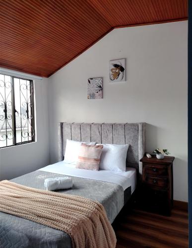 a bedroom with a bed and a window at CASA CIELO Hermosa casa cerca al centro de Paipa in Paipa