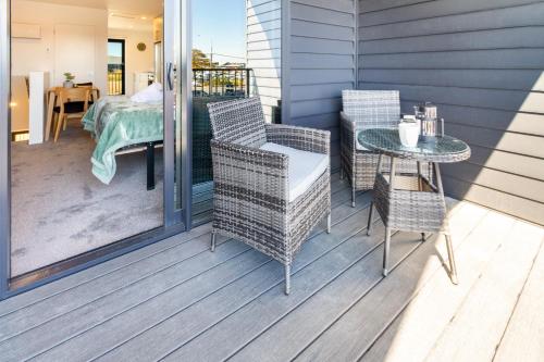 a porch with a table and chairs and a bed at City Living: Upper Studio Haven on Wilmer in Christchurch