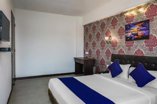 een slaapkamer met een groot bed met blauwe kussens bij Kharadi in Kharadi