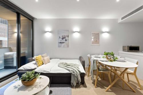 Cette chambre comprend une table, un lit et une salle à manger. dans l'établissement A Chic & Comfy 2BR Apt Near Federation Square, à Melbourne