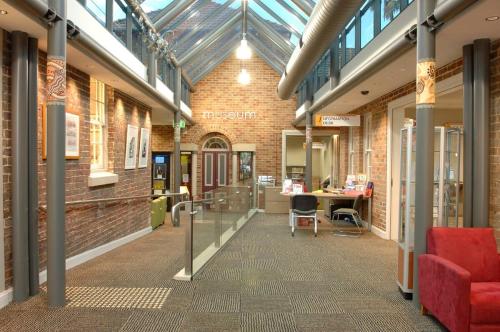 a hallway in a brick building with a red couch at Aircabin - Cobbitty - Lovely - 5 Beds House in Cobbitty