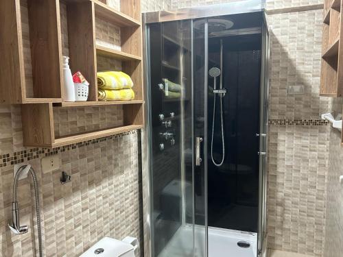 y baño con ducha y puerta de cristal. en Departamento cerca a centros comerciales, en Cajamarca