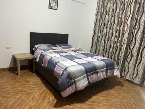 Un dormitorio con una cama y una mesa. en Departamento cerca a centros comerciales en Cajamarca