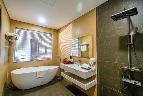 a bathroom with a large tub and a sink at Hoang Son Peace Hotel in Ninh Binh