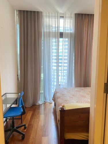 a bedroom with a bed and a chair and a window at Avenue K in Kuala Lumpur