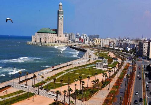 uma cidade com uma torre de relógio ao lado do oceano em Yanis guest house em Casablanca