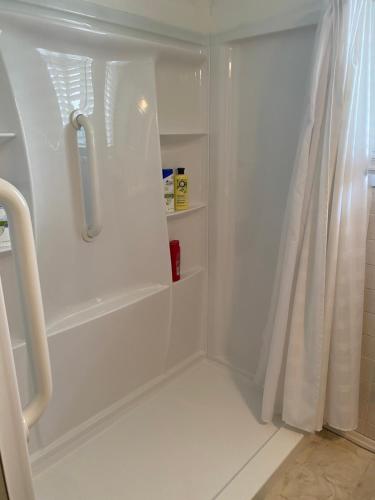 eine weiße Dusche mit Duschvorhang im Bad in der Unterkunft George's B&B in Lewiston