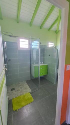a bathroom with a glass shower and a sink at Villa confortable 45m² in Anse-Bertrand