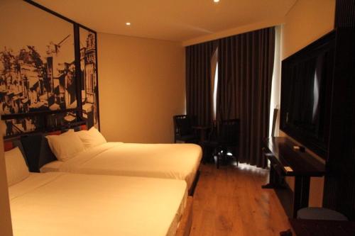 a hotel room with two beds and a flat screen tv at Resort CONDOTEL Apec Mũi Né PS 1 Phòng Ngủ in Ấp Thiẹn Ái