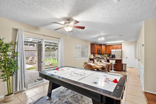 a living room with a ping pong table in it at Houston Pool Retreat WiFi Yard BBQ Games TVs in Houston