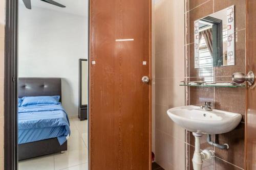 un bagno con un lavandino, un letto e uno specchio di Venus.28 Melaka Homestay ad Ayer Keroh