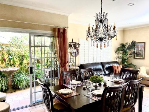 a dining room with a table and a chandelier at CASA LUX MONICA Prime Santa Monica Luxury Home ONE-OF-A-KIND in Los Angeles