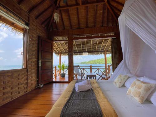 a bed in a room with a view of the ocean at Floating Paradise in Karimunjawa