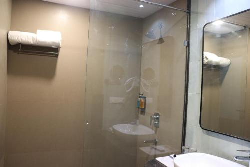 a bathroom with a glass shower with a sink at Ramee Royal Resort & Spa - Udaipur in Udaipur