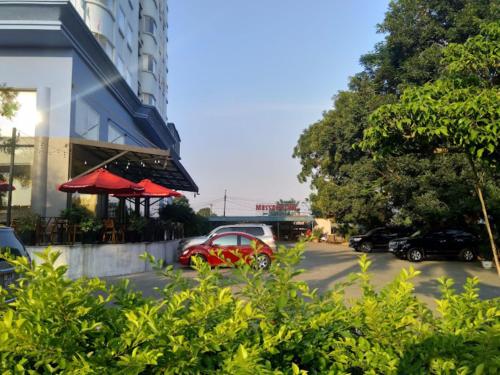 un coche rojo estacionado en un estacionamiento al lado de un edificio en Phù Đổng Hotel Thanh Hóa, en Thanh Hóa