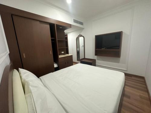 a bedroom with a bed and a flat screen tv at Ngoc Thu Palace in Soc Trang