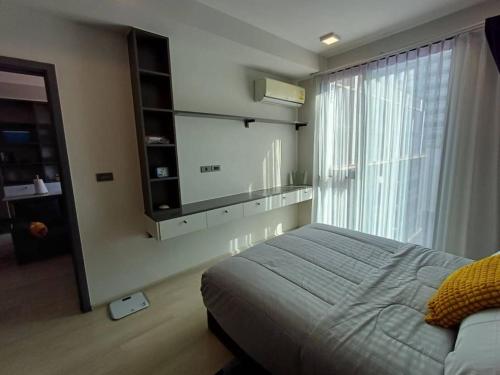 Sukhumvit Soi 10 Stay in Style في Klong Toi: غرفة نوم بسرير ونافذة كبيرة