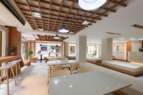 a lobby of a restaurant with tables and chairs at Grand Watergate Hotel in Bangkok