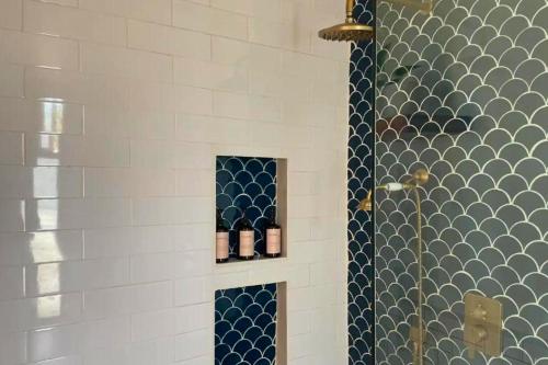 La salle de bains est pourvue d'une douche avec du carrelage bleu et blanc. dans l'établissement Kerasia 2 BR Villa With Private Pool NE61, à Gili Air