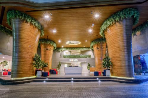 a lobby with columns and plants in a building at HOMA Cherngtalay Phuket in Bang Tao Beach