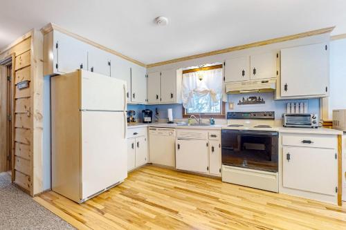 a kitchen with white cabinets and a refrigerator at Little Bend Haven in Wilmington