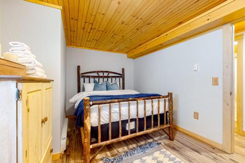 a bed in a room with a wooden ceiling at Little Bend Haven in Wilmington
