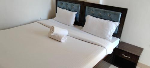 een groot bed met witte lakens en witte kussens bij Ayodhya-couple friendly Hotel by prithvi yatra hotel in Ayodhya