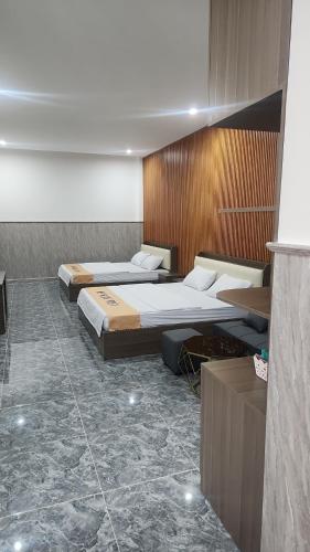 2 bedden in een kamer met marmeren vloeren bij HOTEL SONG TIÊN in Trà Vinh