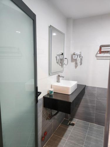 Trà Vinh的住宿－HOTEL SONG TIÊN，一间带水槽和镜子的浴室
