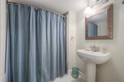 a bathroom with a shower curtain and a sink at Scotchmere Serenity: Modern 1-Bedroom Brampton Haven in Brampton