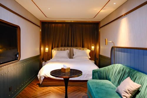 - une chambre avec un lit, une table et un canapé dans l'établissement Xinyu Hotel - Shanghai Jiao Tong University Xinhua Road, à Shanghai