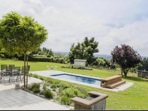 特鎮的住宿－Spacious villa with private pool in Theux，后院设有游泳池、桌子和椅子