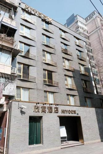 上海市にあるXinyu Hotel - Shanghai Jiao Tong University Xinhua Roadの側面に文字が書かれた高い建物