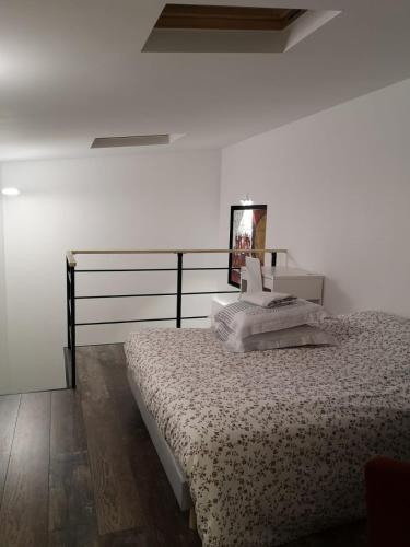 une chambre avec un lit et un mur blanc dans l'établissement Les Lofts De Livry: Appartement 2, à Livry-Gargan