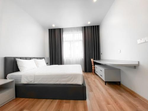 ein Schlafzimmer mit einem Bett und einem Schreibtisch. in der Unterkunft Metahome Apartment HOT Độc Đáo Nhất Vinhome Marina in Haiphong