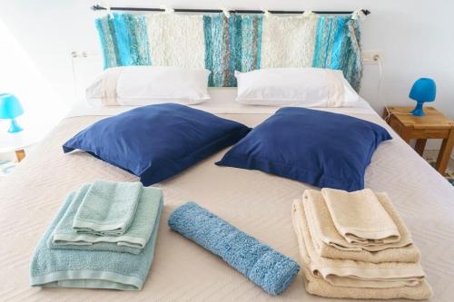 een bed met blauwe kussens en handdoeken erop bij Casa Fiorella en Cabo de Gata. in Níjar