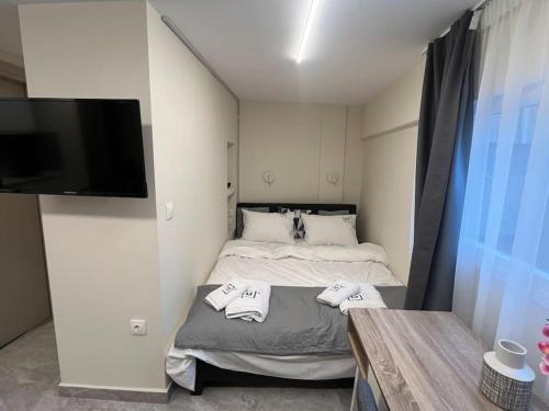 1 dormitorio con 1 cama con toallas en Odyssey Apt 3, en Tesalónica
