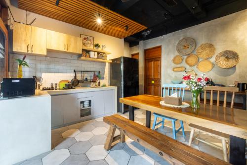 uma cozinha com uma mesa de madeira e um banco de madeira em Interconnection Hostel em Kuta