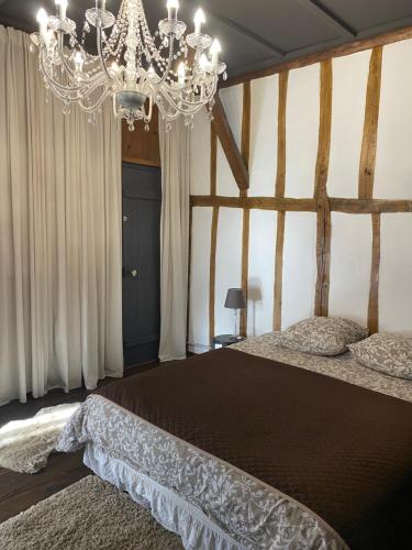 1 dormitorio con 1 cama grande y lámpara de araña en Chaleureux, 