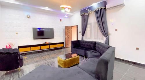 sala de estar con sofá y TV en CEO HOMES AND APARTMENT, en Warri